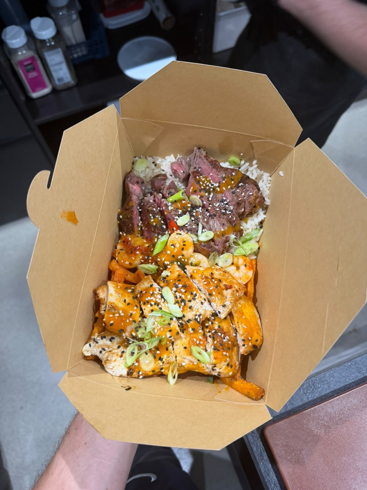 Steak, chicken and prawn box over rice with sesame and spring onion